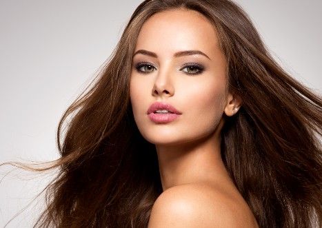 Joven modelo posa con un cabello brillante y sedoso